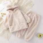 Photo d'un ensemble de pyjama cocooning en peluche pour bébé Un pantalon et un sweat à capuche beige