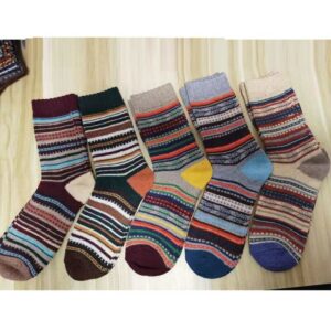 Photo de 5 paires de chaussettes en laine à motifs multicolores posées sur du parquet