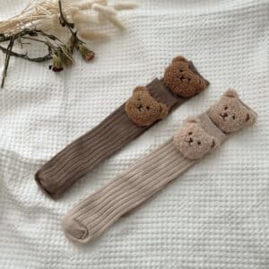 Chaussettes montantes en coton pour bébé avec un ours en peluche dessus.
