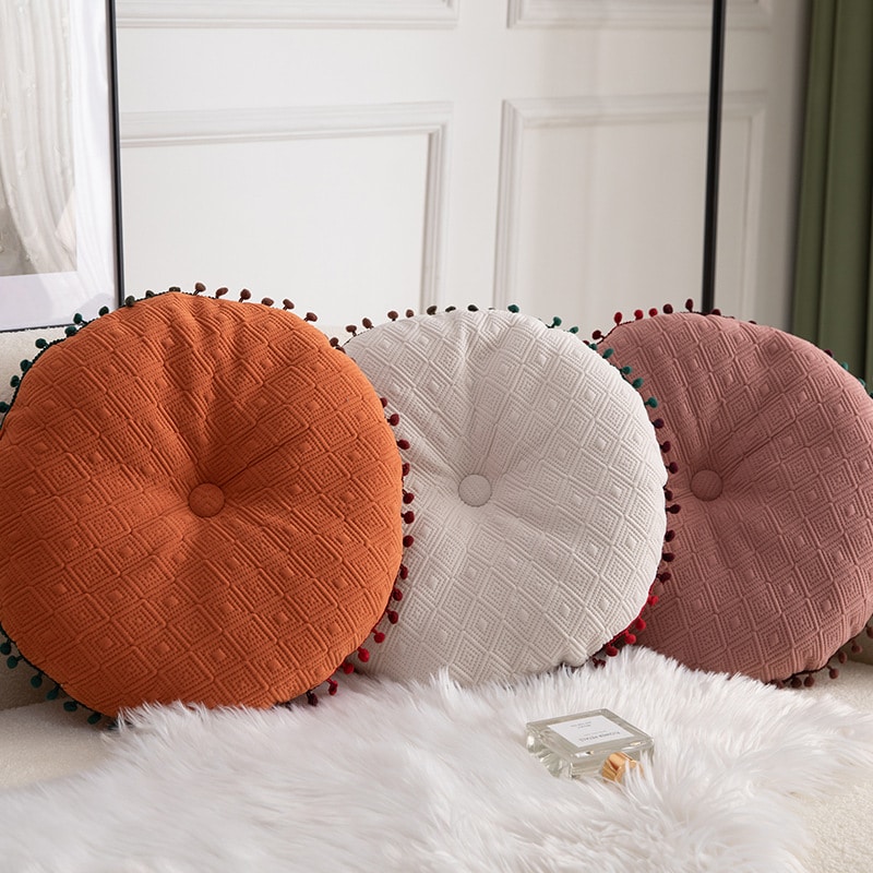 Coussin cocooning rond à pompons