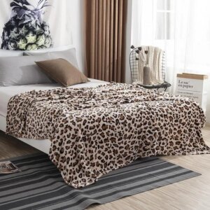 Photo d'une couverture imprimée léopard posée sur un lit dans une chambre de style moderne.