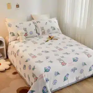 Photo d'un plaid posé sur un lit comme une couverture avec des motifs de fleurs et des coussins assortis.