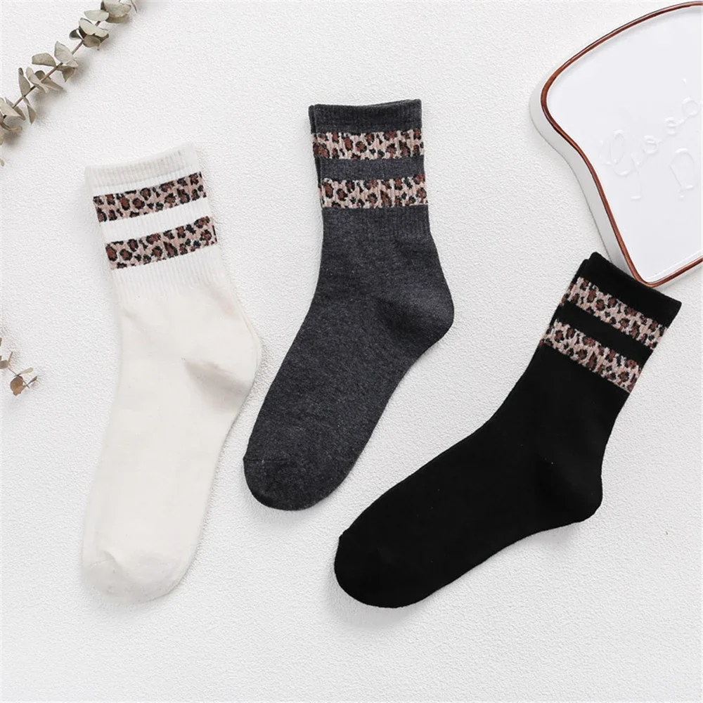 Chaussettes à rayures léopard, une blanche, un grise et une noire.